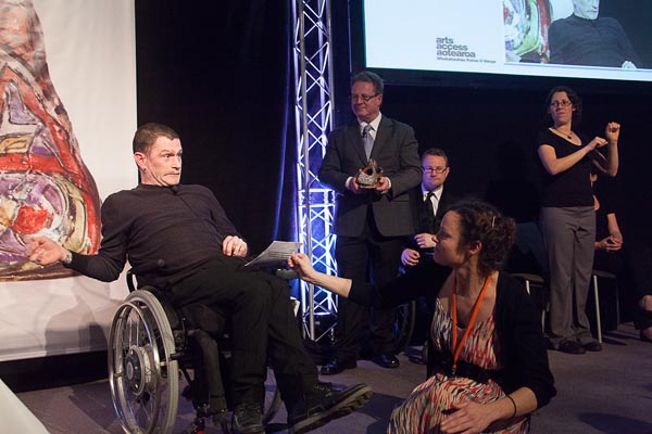 Philip Patston accepts an award on stage at the 2014 Arts Access Awards.
